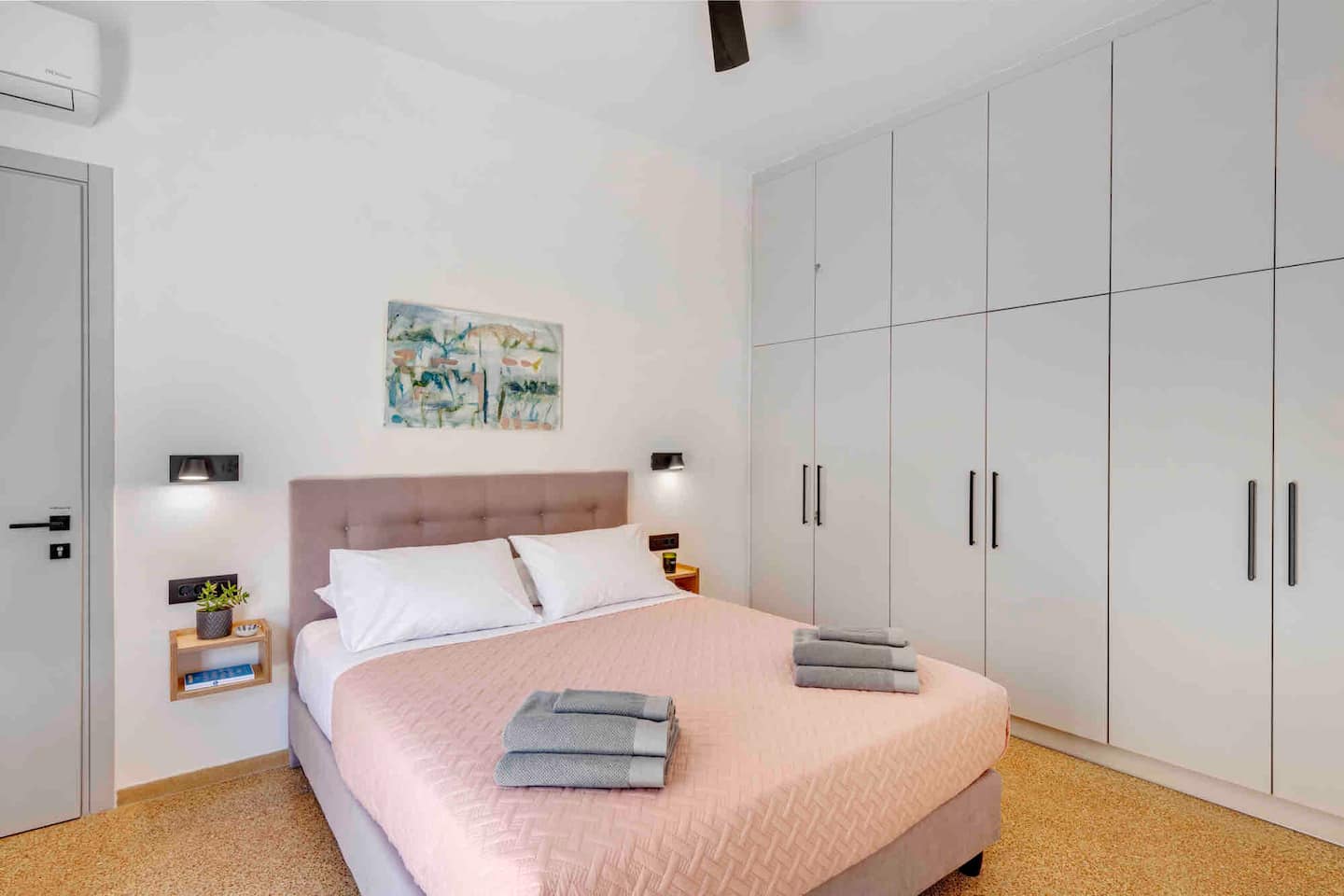 Second bedroom with blush bedspread and built-in wardrobes