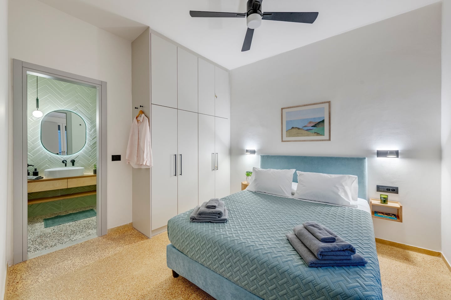 Main bedroom with teal bedhead and ensuite bathroom