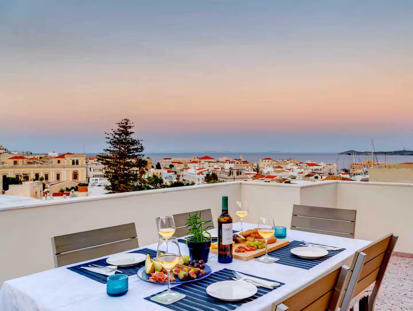 Sunset dinner on the penthouse terrace overlooking the rooftops of Ermoupoli and the blue Aegean